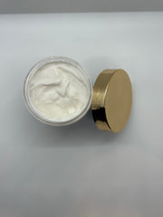 Jar of body butter with a gold lid on a light gray background