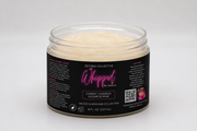 A jar of Setoria Collective Whipped Island Groove Sugar Scrub without a lid, featuring a black label with pink and white text set against a neutral gray background.
