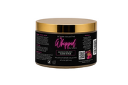 A jar of Setoria Collective Whipped by Setoria Mango Melody Sugar Scrub, featuring a black label with pink and white text and a metallic gold lid, set against a white background.