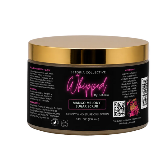 A jar of Setoria Collective Whipped by Setoria Mango Melody Sugar Scrub, featuring a black label with pink and white text and a metallic gold lid, set against a white background.